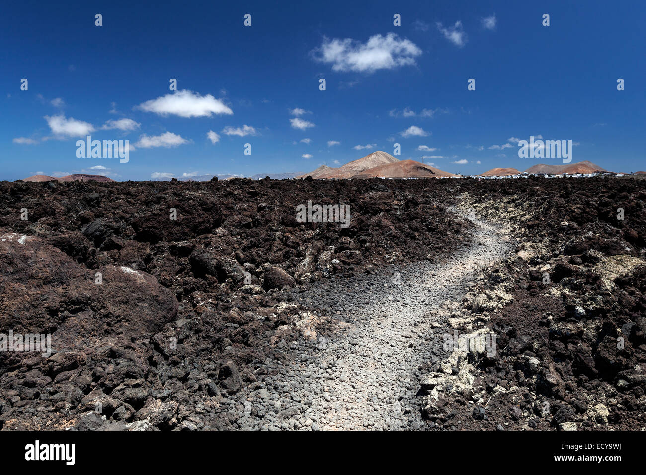 Chemin à travers un champ de lave paysage volcanique, incendie, montagnes, volcans, Mancha Blanca volcan dans le dos, Lanzarote Banque D'Images