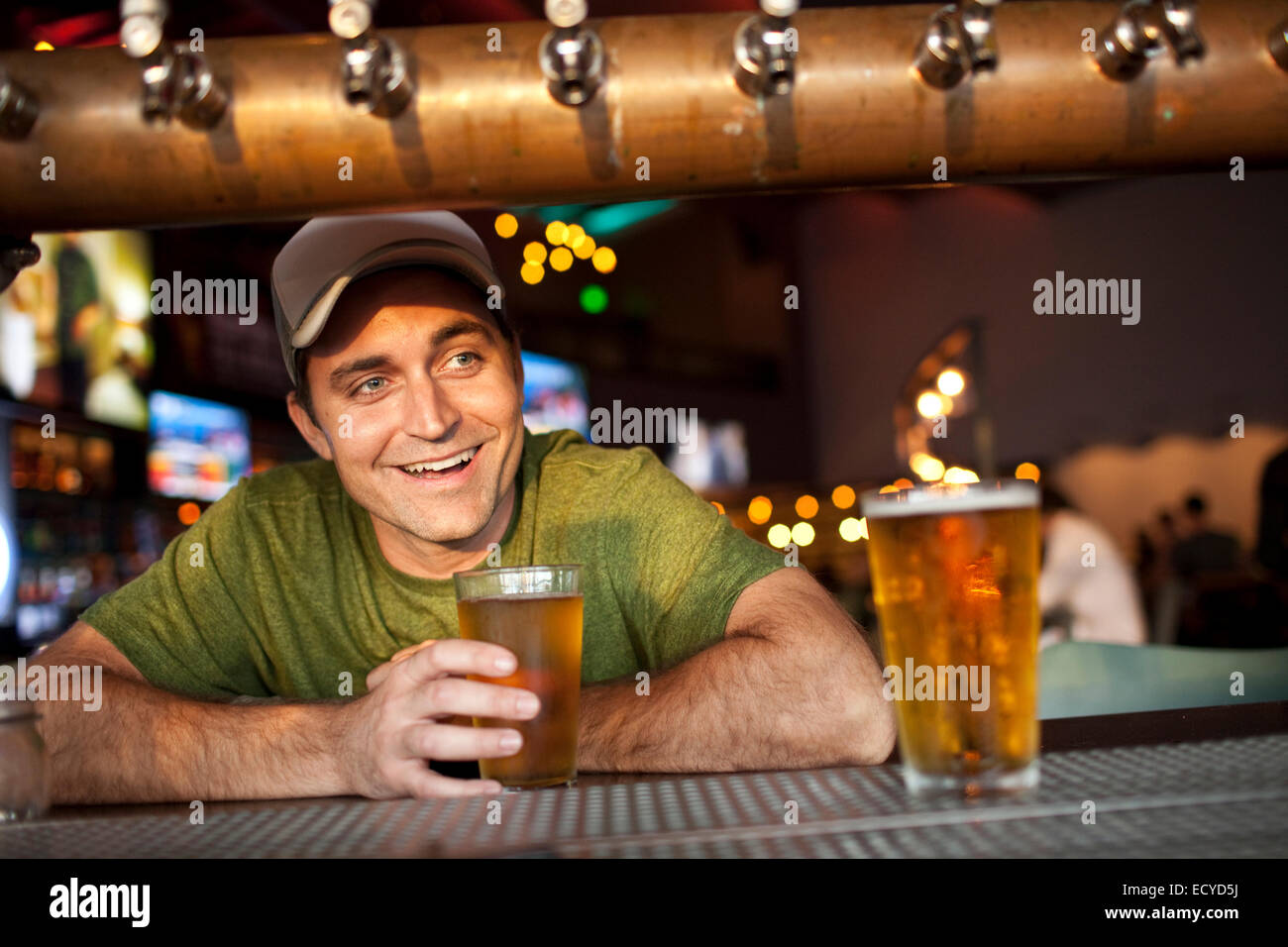 Young man drinking beer en bar Banque D'Images