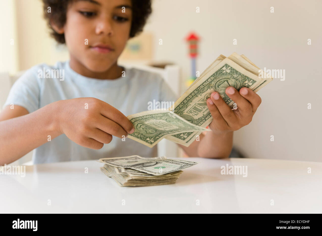 Mixed Race boy counting money Banque D'Images