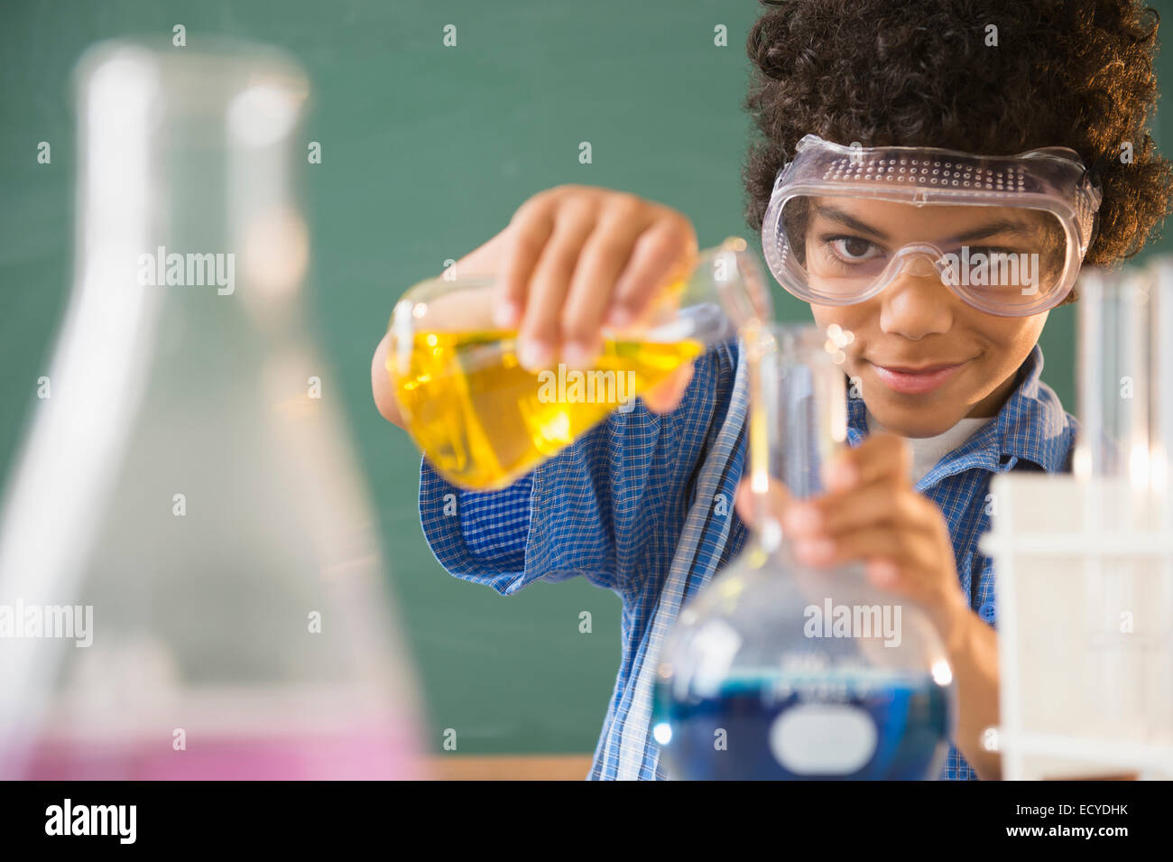 Mixed Race boy expérimentant dans classe science lab Banque D'Images