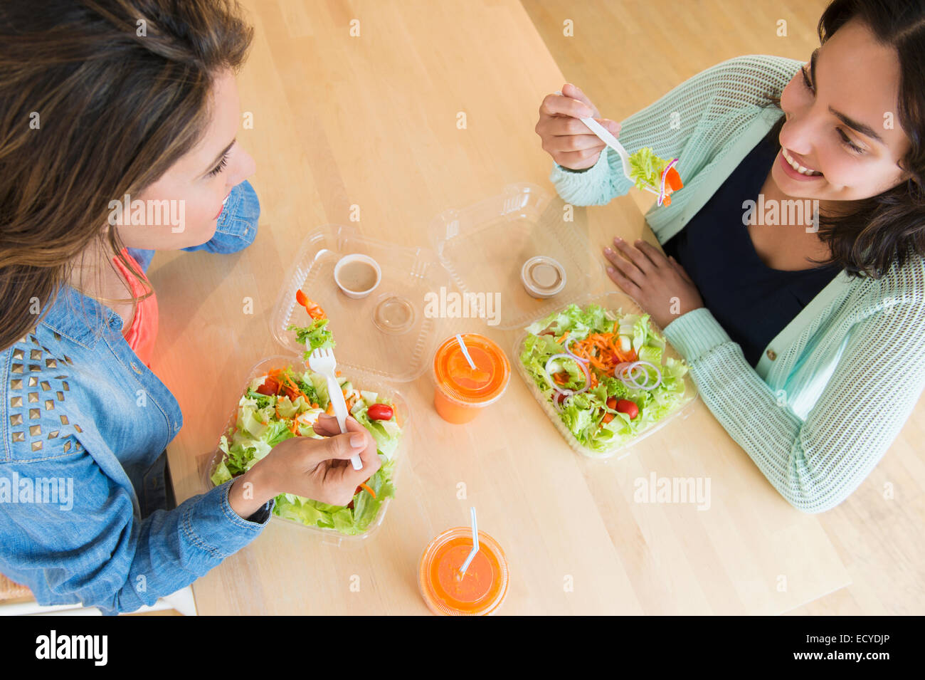 Les femmes hispaniques salade manger ensemble à table Banque D'Images