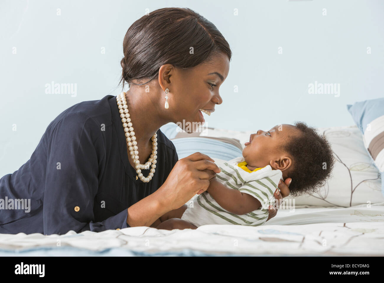 Mère berçant son bébé sur le lit Banque D'Images