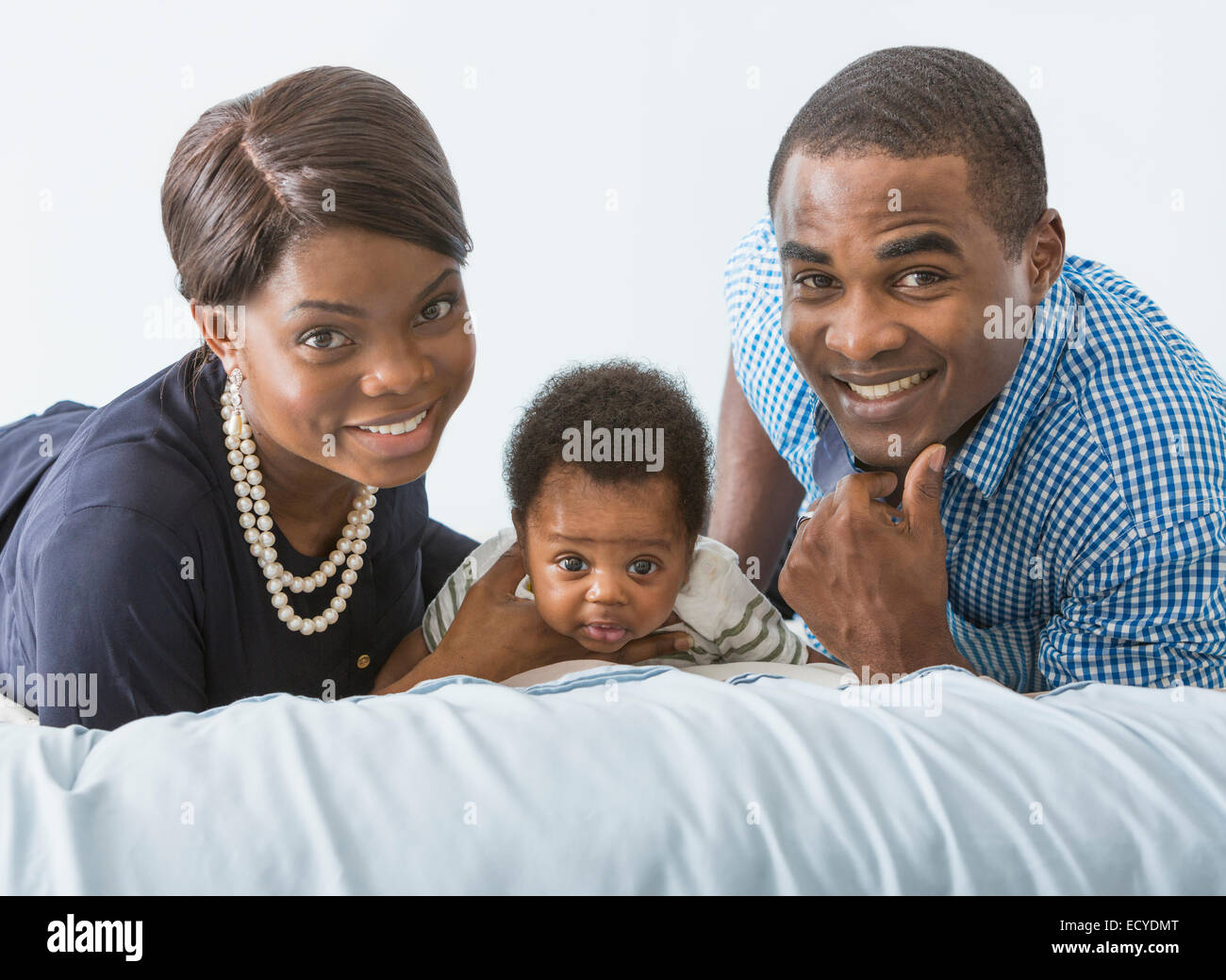 Couple smiling with baby son on bed Banque D'Images
