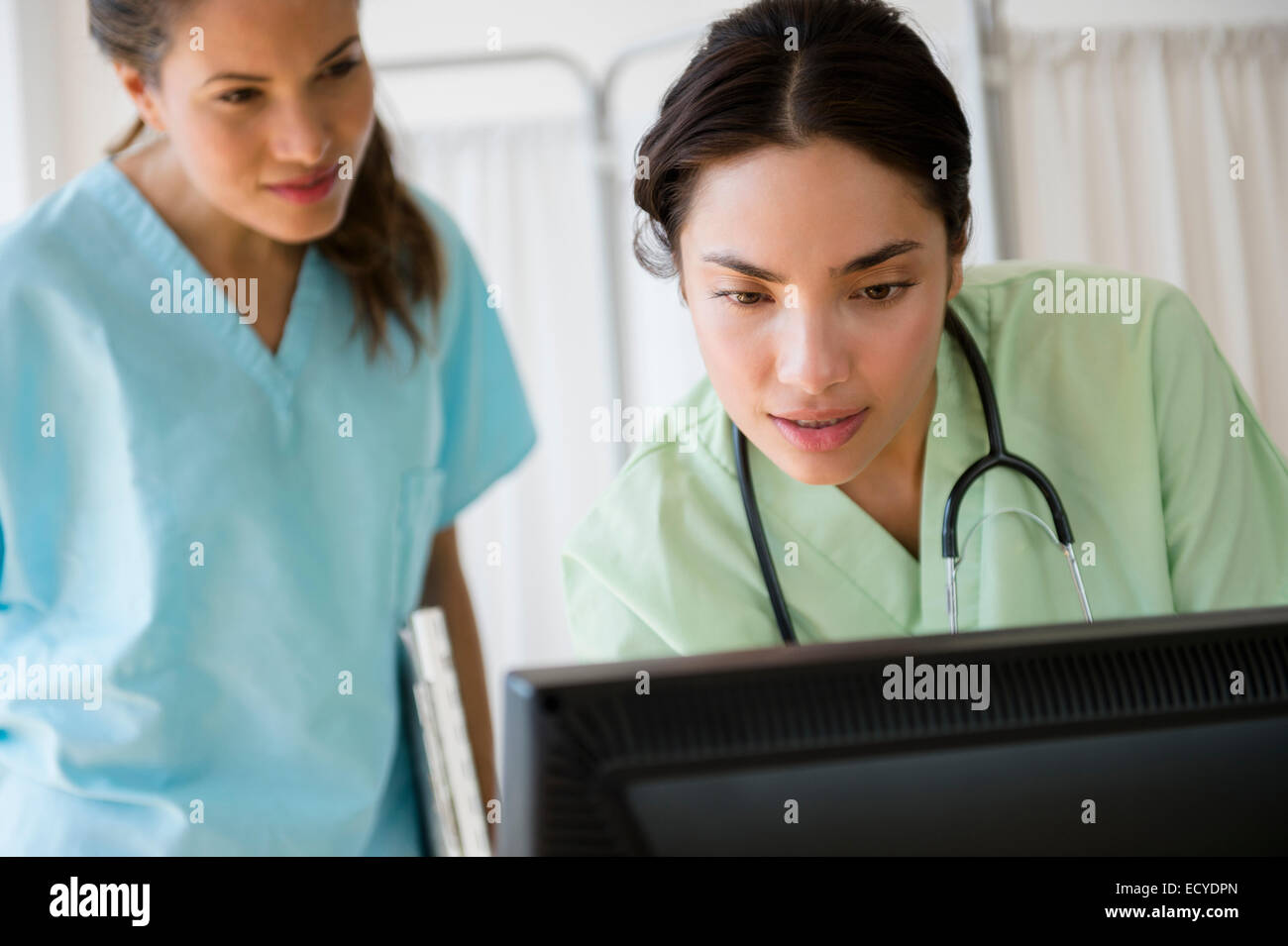 Les infirmières hispaniques travaillant ensemble sur ordinateur à l'hôpital Banque D'Images