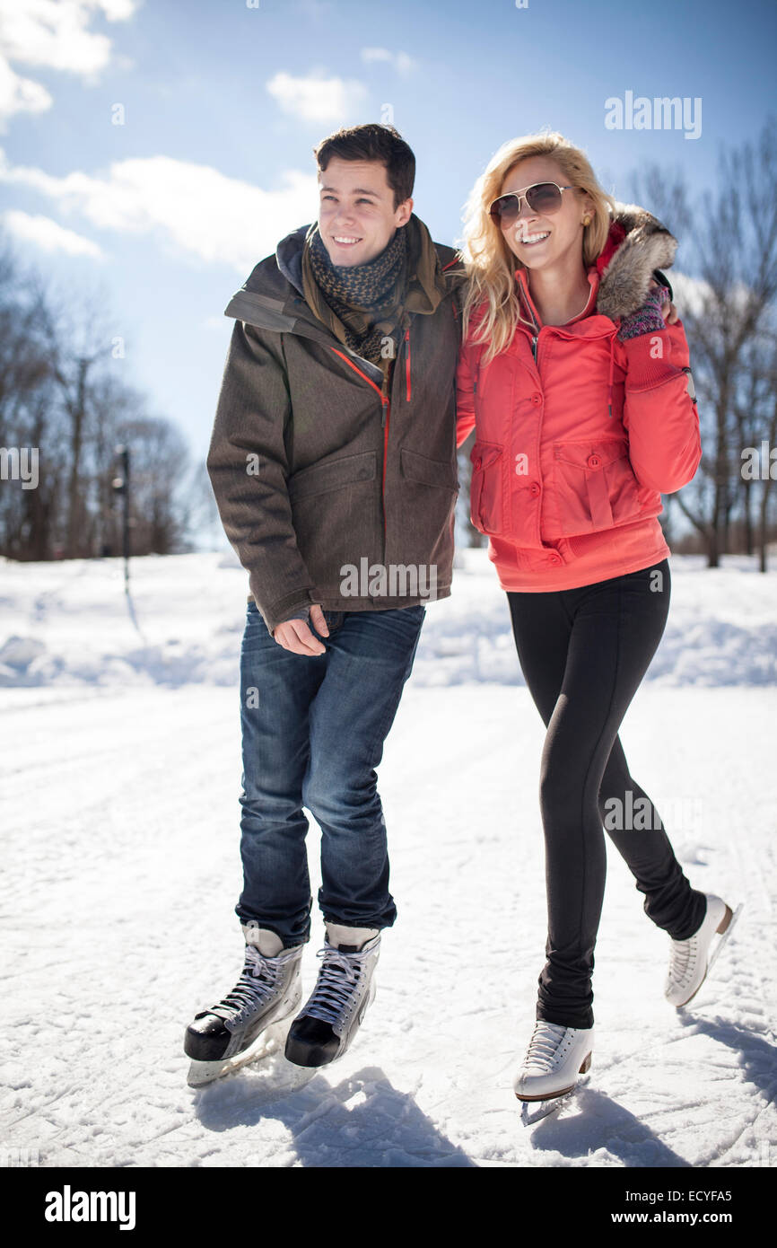 Caucasian couple patinage sur lac gelé Banque D'Images