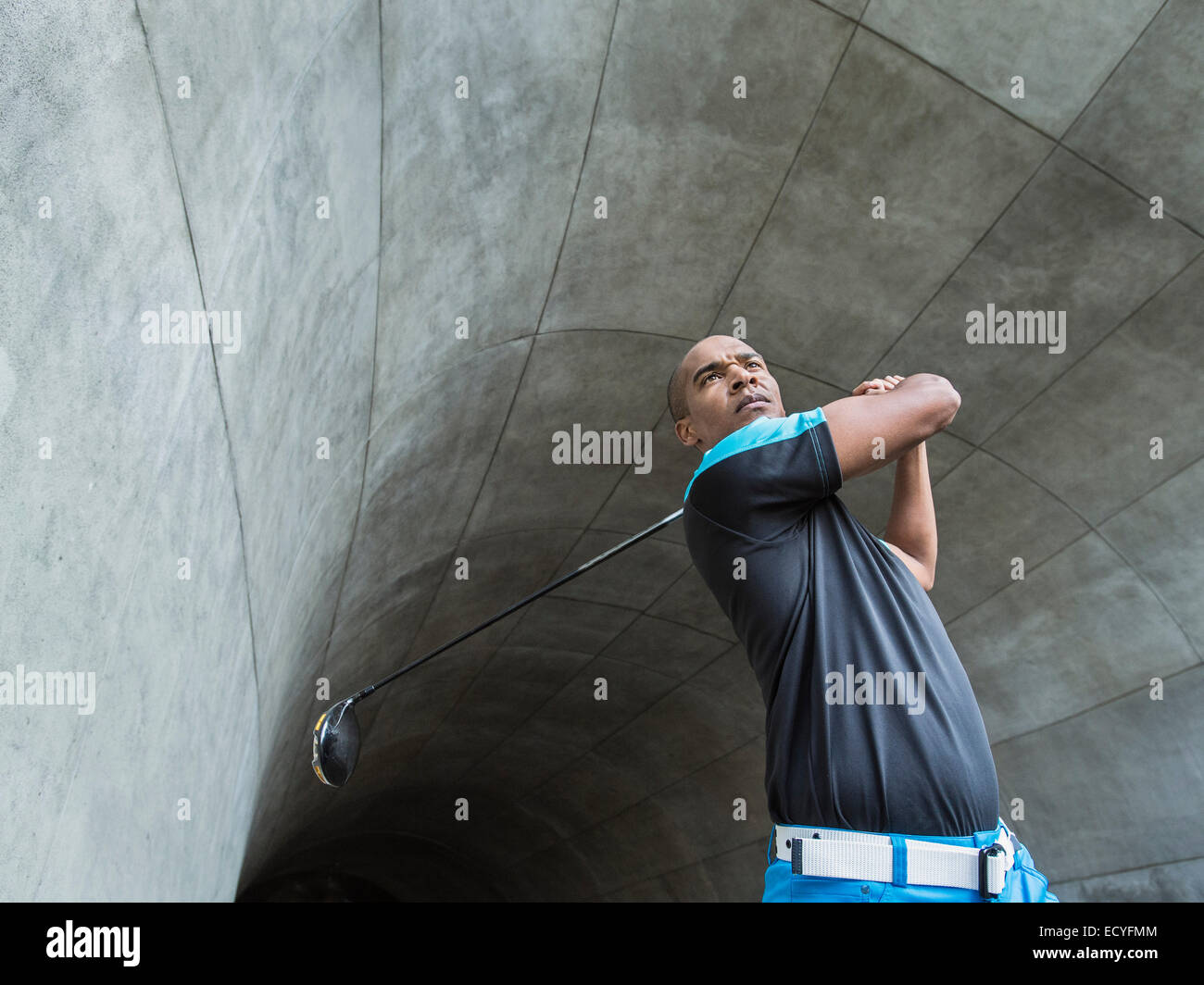 Homme noir jouer au golf au tunnel urbain Banque D'Images