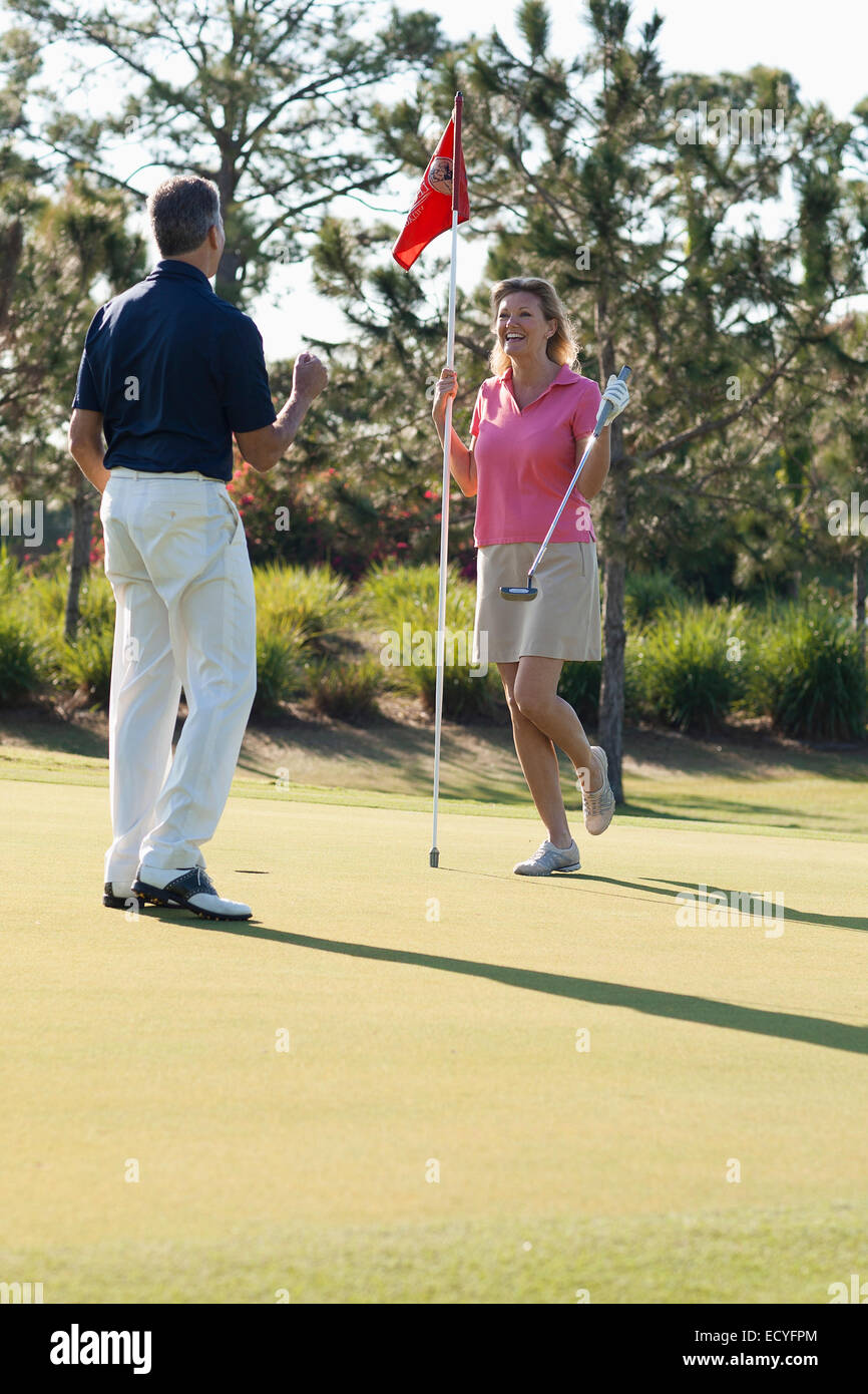 Caucasian couple playing golf on course Banque D'Images