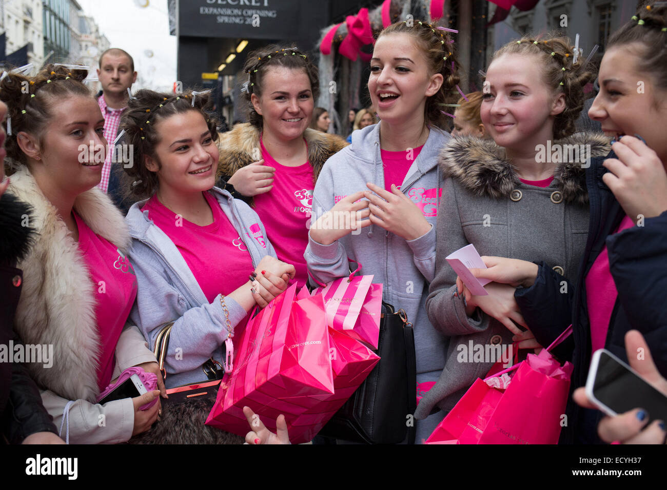 Groupe de filles avec leurs cheveux en portant des bigoudis et rose. Londres, Royaume-Uni. Banque D'Images