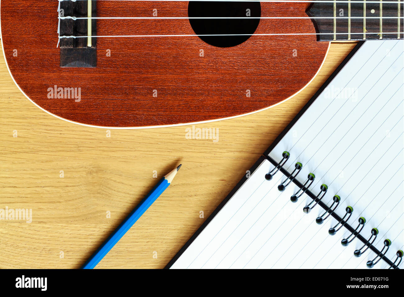 Ukulele guitare avec bloc-notes et un crayon blanc Banque D'Images