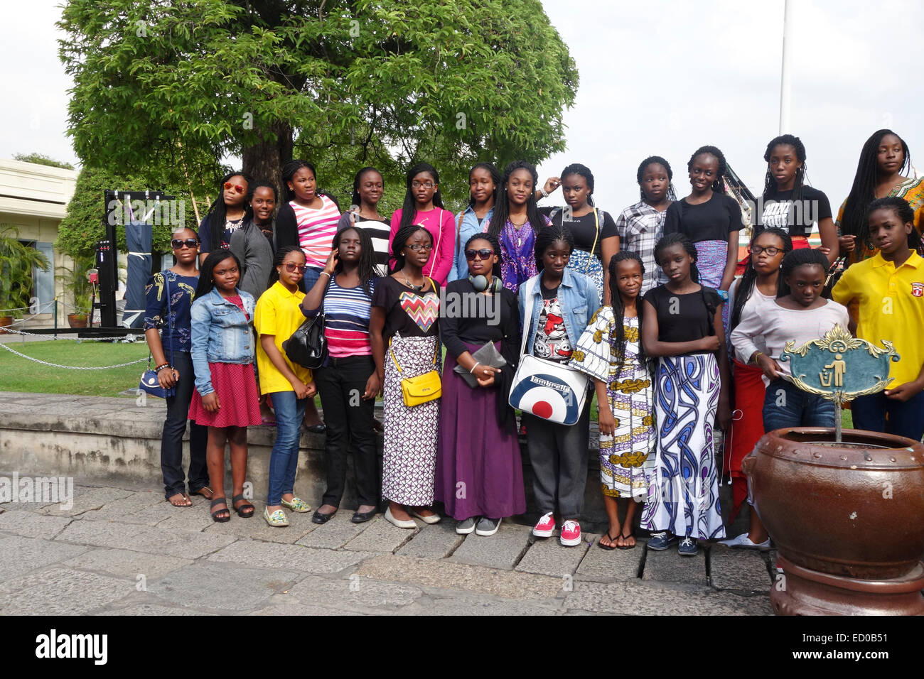 Jeune femme africaine Groupe de touristes posant à la cour extérieure du roi Le Grand Palais, Wat Phra Kaew, Bangkok, Thaïlande. Banque D'Images