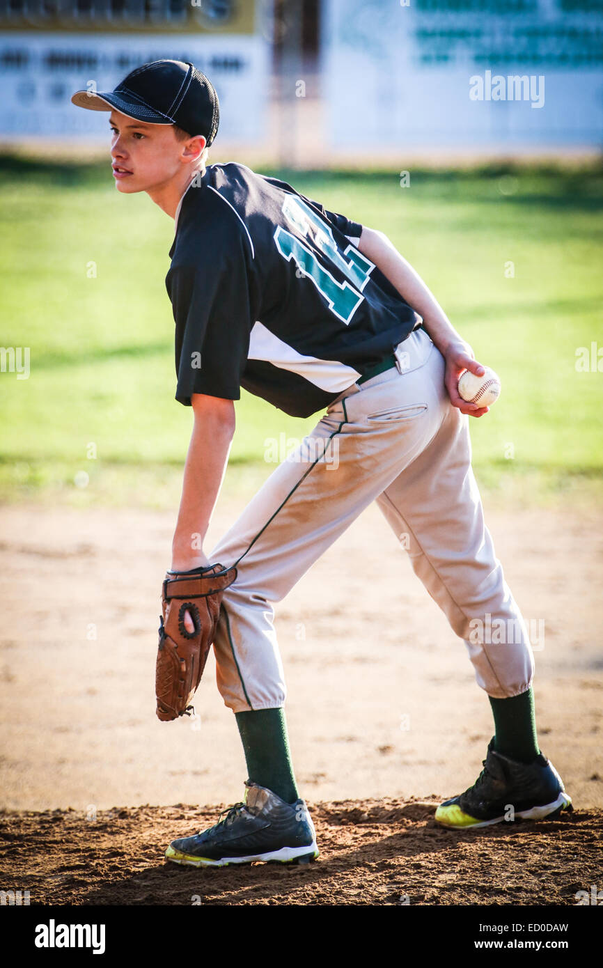 Boy standing on pitchers mound jouer au baseball Banque D'Images