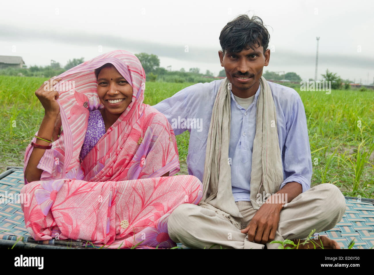 2 Couple marié rurales indiennes sitting farm Banque D'Images