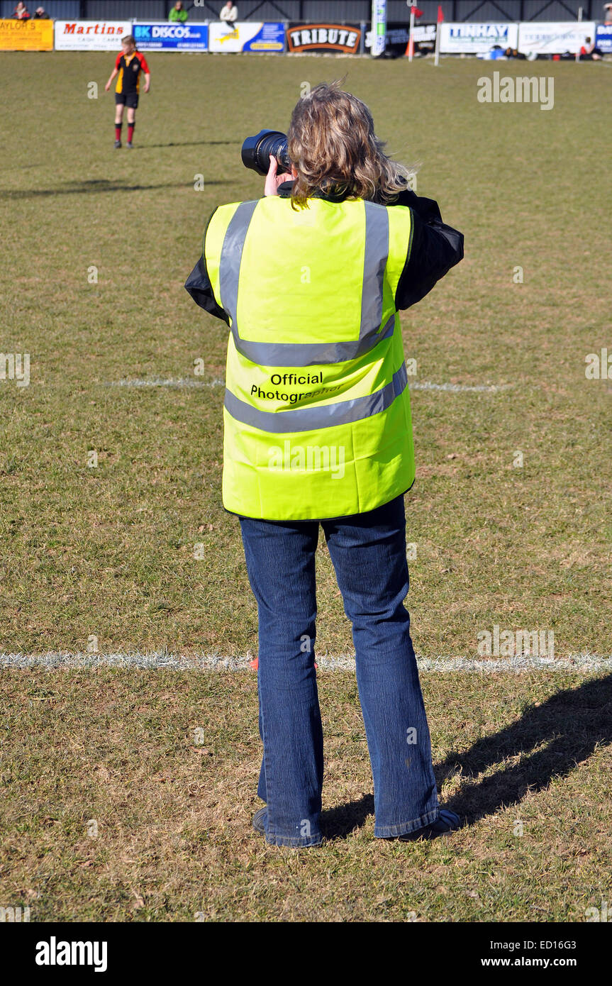 Un photographe de sport professionnel de la prise de photographies à un match de rugby junior Banque D'Images