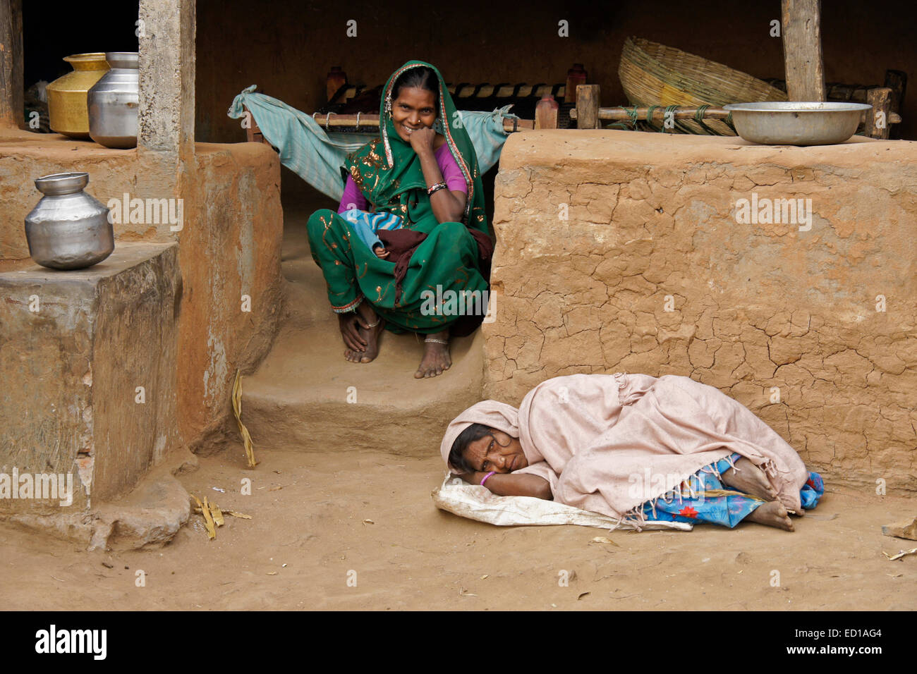 Les femmes de la tribu Adivasi en dehors de leur maison dans village proche de Poshina, Gujarat, Inde Banque D'Images