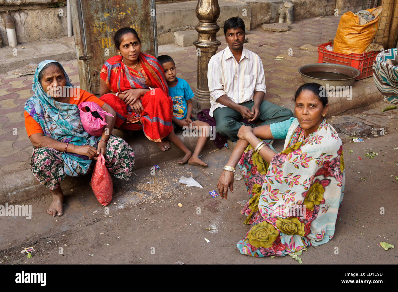 Family sitting on curb dans de vieux Ahmedabad, Gujarat, Inde Banque D'Images