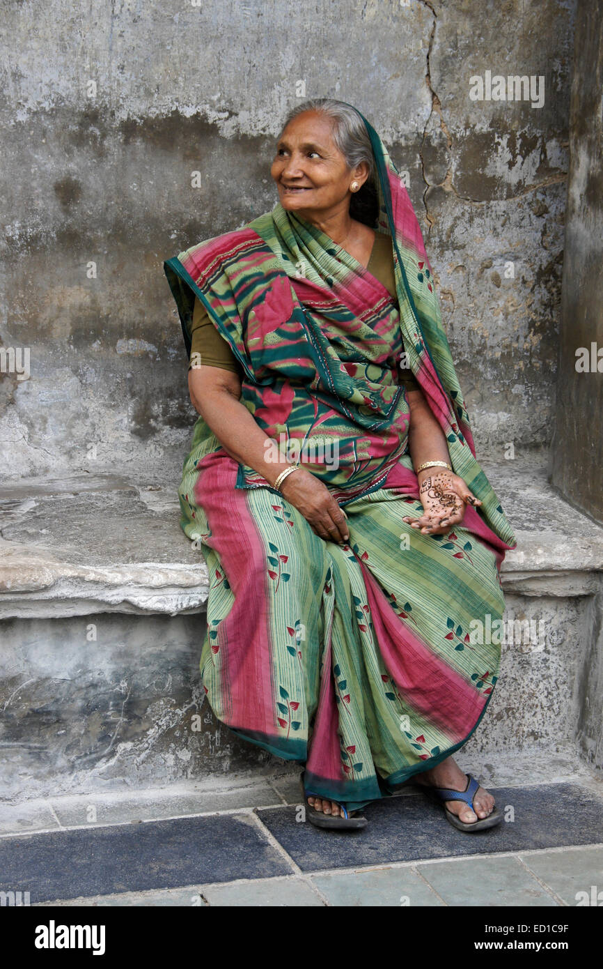 Femme assise à l'extérieur de la maison dans vieux Ahmedabad, Gujarat, Inde Banque D'Images