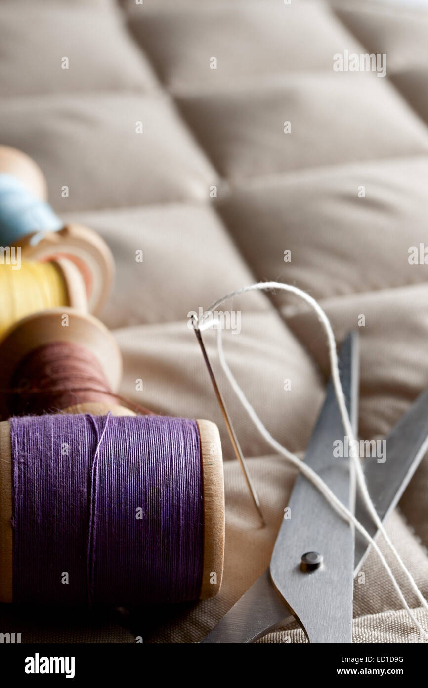 Thread bobines avec des ciseaux sur un tissu gris Banque D'Images