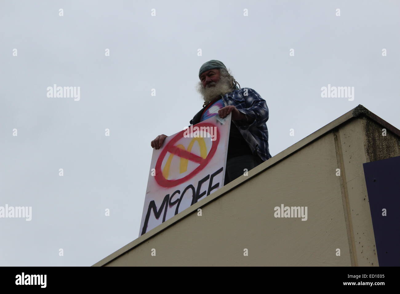 Pas de Mcdonald's dans la région de Tecoma protestataire qui avait escaladé un bâtiment proche de tenir un signe de protestation de la construction de magasins Banque D'Images