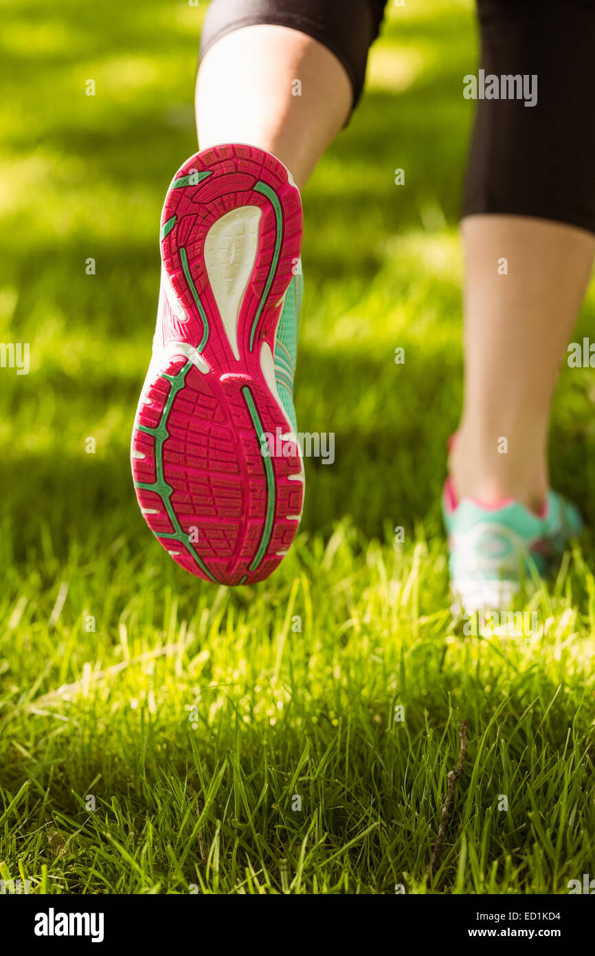 Femme en chaussures de course jogging on grass Banque D'Images