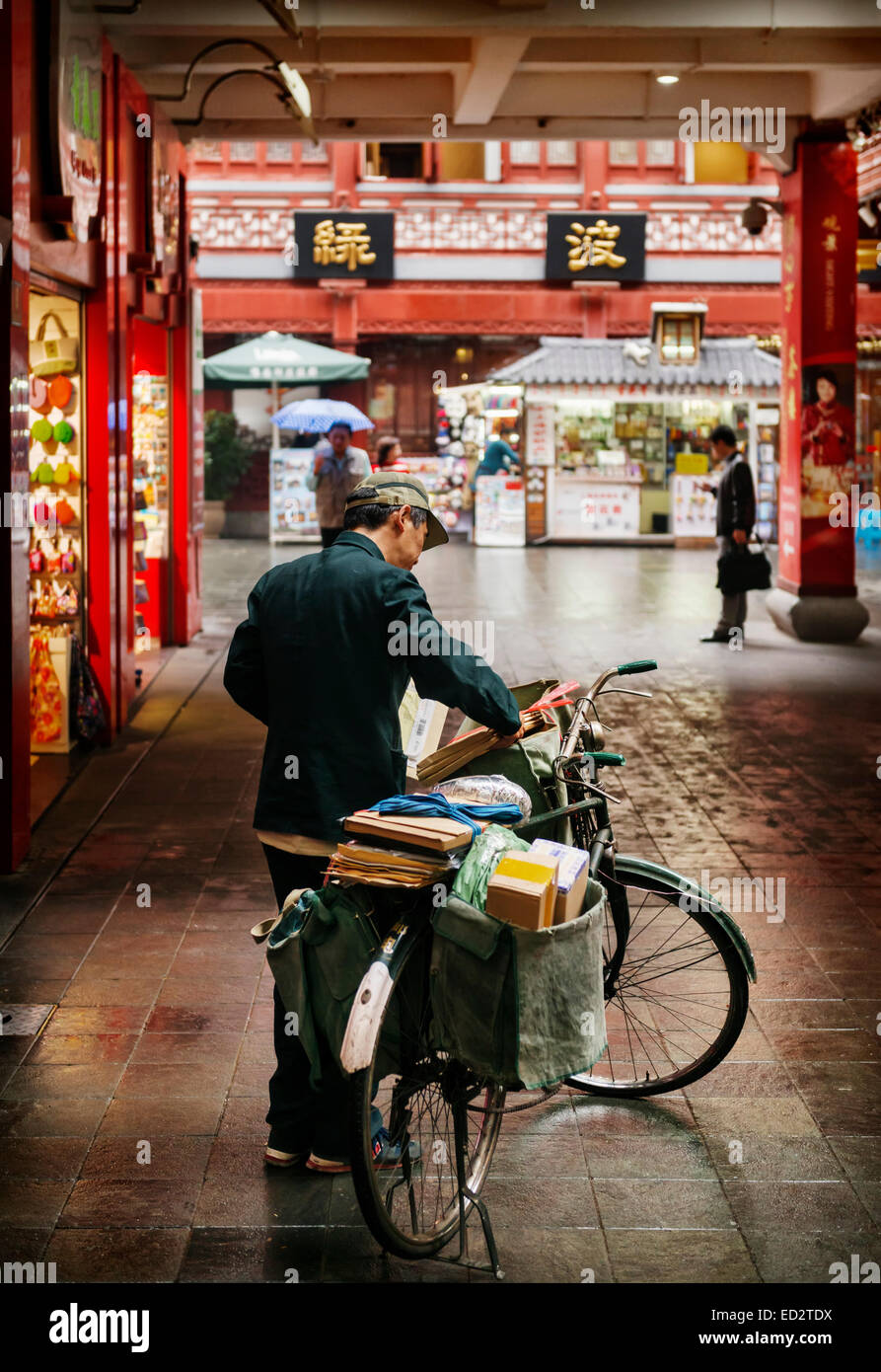 Licence disponible sur MaximImages.com - Postman livrant le courrier à vélo dans la vieille ville de Shanghai, Chine 2014 Banque D'Images