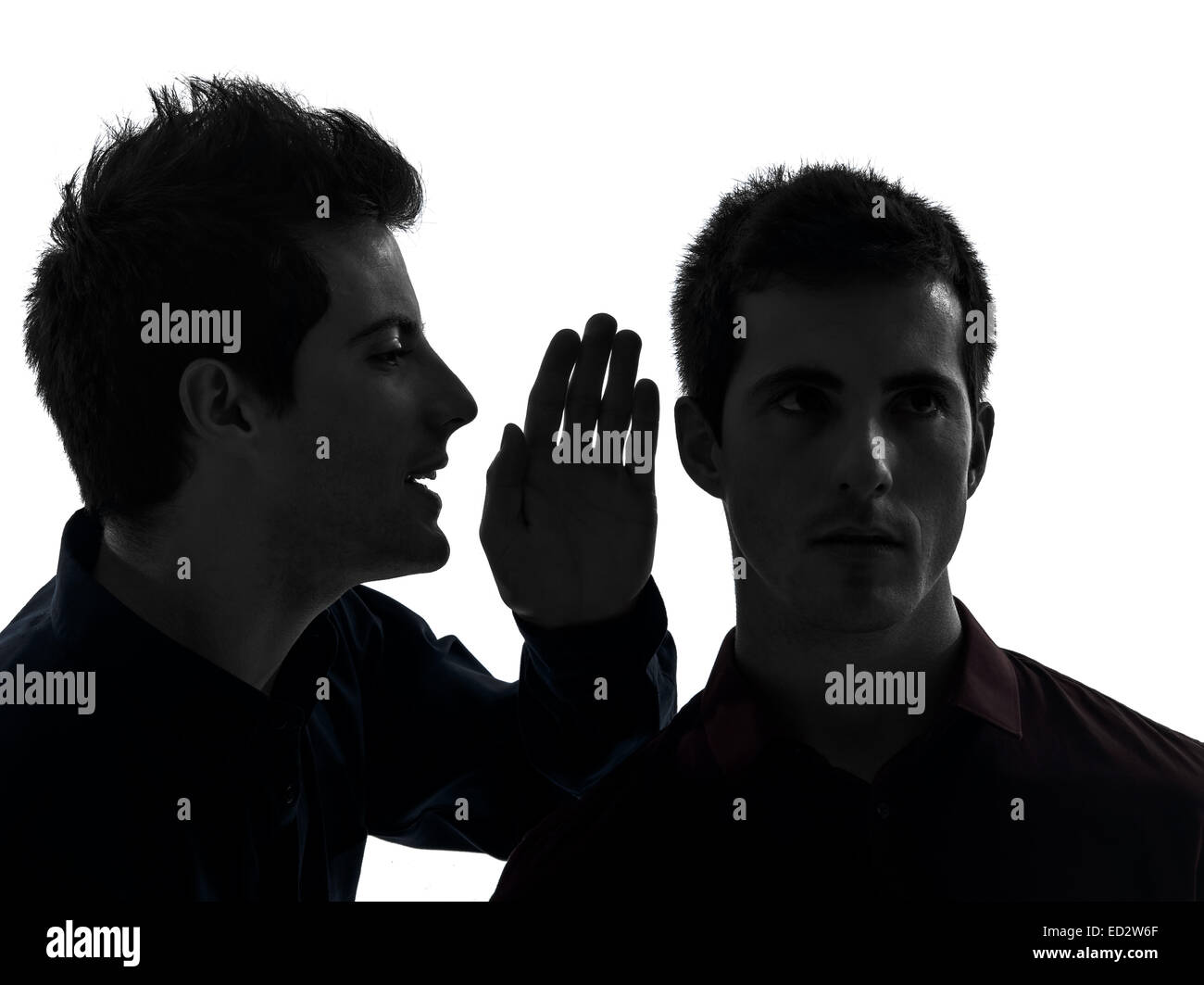 Deux jeunes hommes gossip schyzophrenia concept dans l'ombre fond blanc Banque D'Images