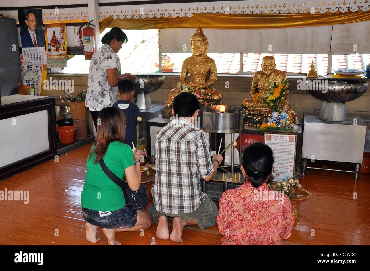 NAKHON PATHOM, THAÏLANDE : Fidèles à genoux en prière devant Bouddha Doré et statues saint moine au temple Phra Pathom Chedi Banque D'Images