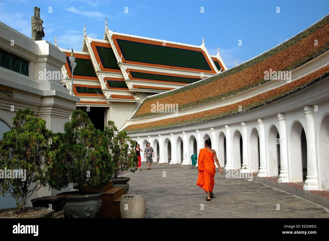 NAKHOM PATHOM, THAÏLANDE : UN MOINE FLÂNANT MARCHE DERNIÈRES ARQUA COLONADE APPROCHANT L'OUEST VIHARA à Phra Pathom Chedi Banque D'Images