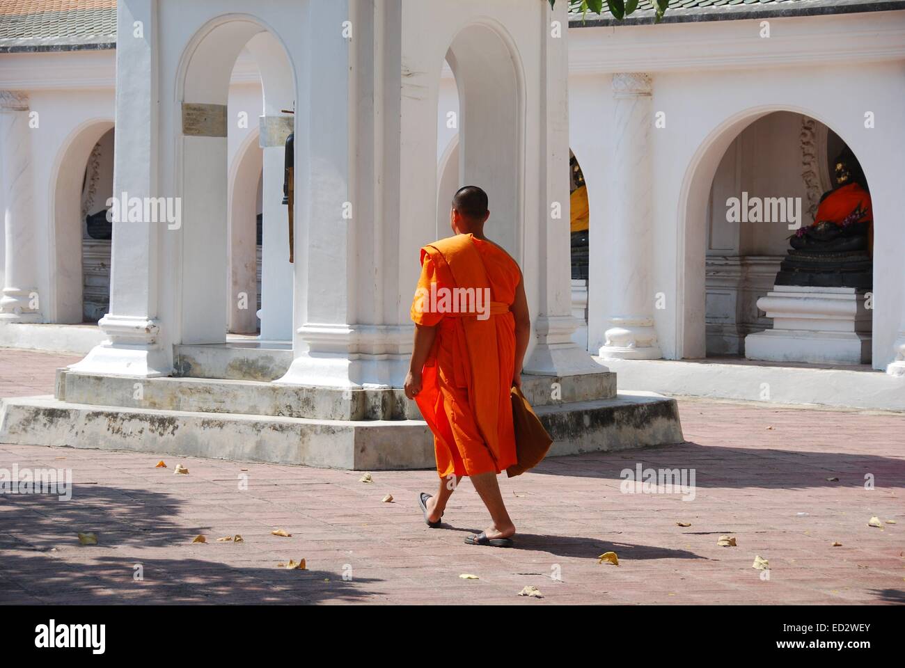 NAKHON PATHOM, THAÏLANDE : un moine portant une robe orange marche dernières tour du beffroi et la galerie du cloître circulaire * arches Banque D'Images