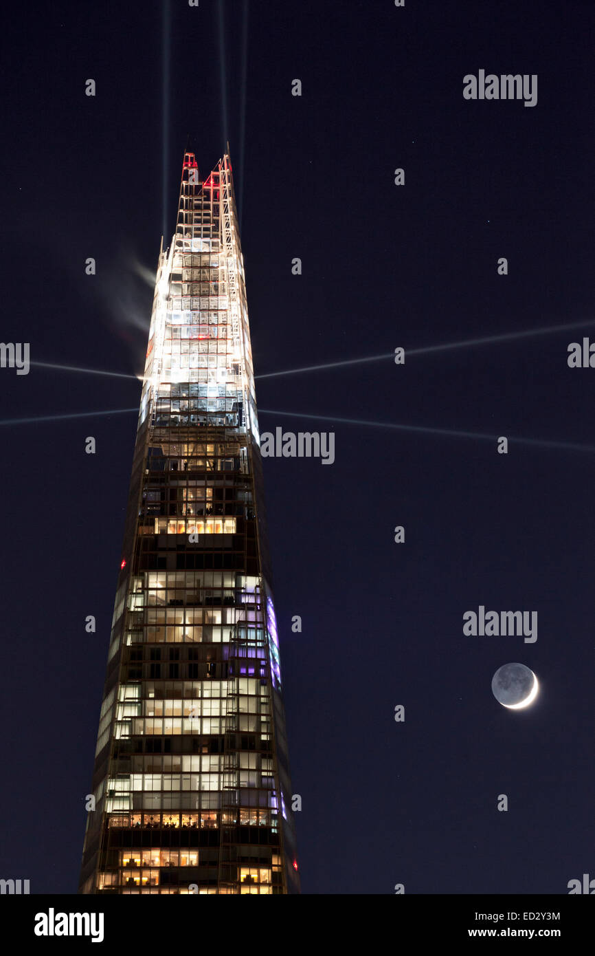 Londres, Royaume-Uni. Le 24 décembre, 2014. Spectacle de lumière en haut de l'Shard avec la Lune croissante juste après le coucher du soleil. Crédit : David Bleeker Photography.com/Alamy Live News Banque D'Images