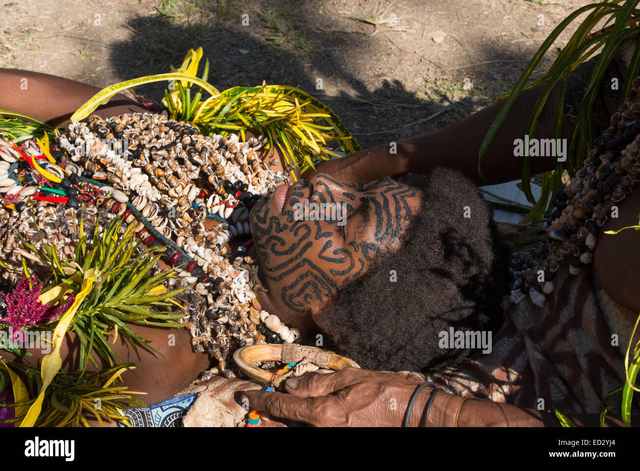 En Mélanésie, la Papouasie-Nouvelle-Guinée, Tufi. Femme, portant des colliers de coquillage, laissant son nouveau visage peint tattoo. Banque D'Images