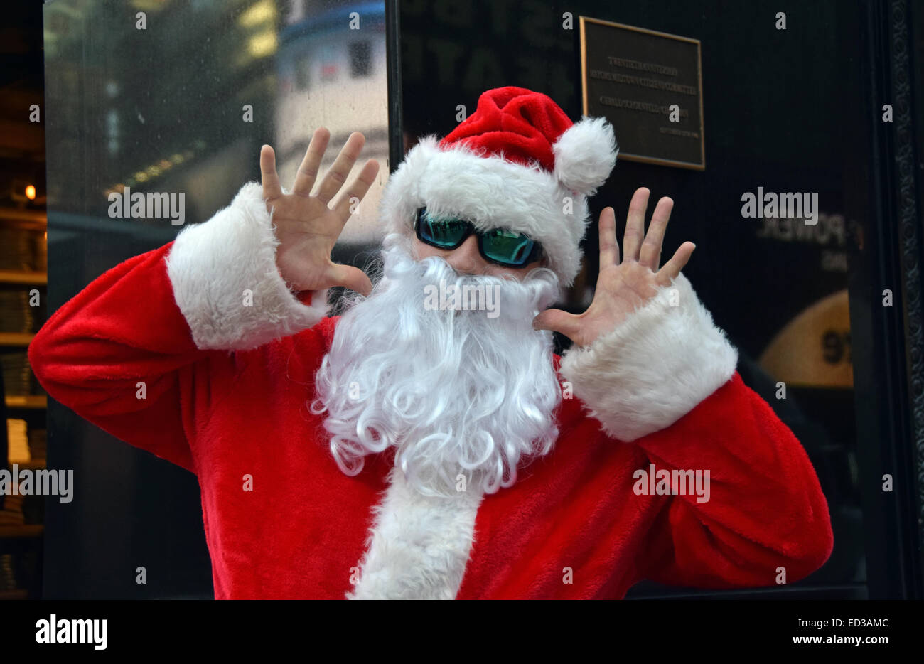 Un homme dans un costume du Père Noël, faire des grimaces à l'appareil photo à Times Square, Midtown, Manhattan, New York City Banque D'Images