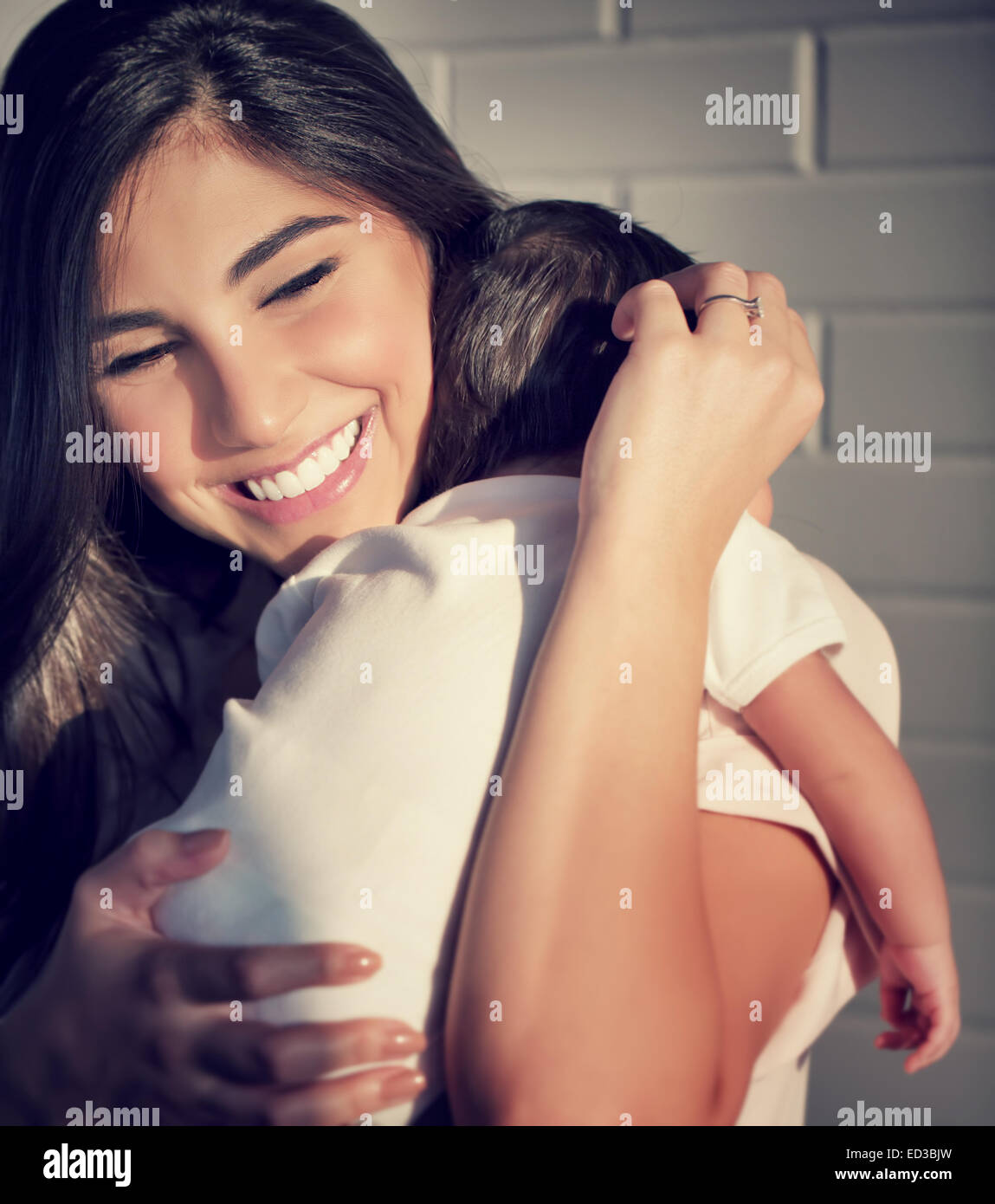 Closeup portrait of cute smiling mother holding sur les mains petit bébé, de s'amuser à la maison, heureux parents, famille amour concept Banque D'Images