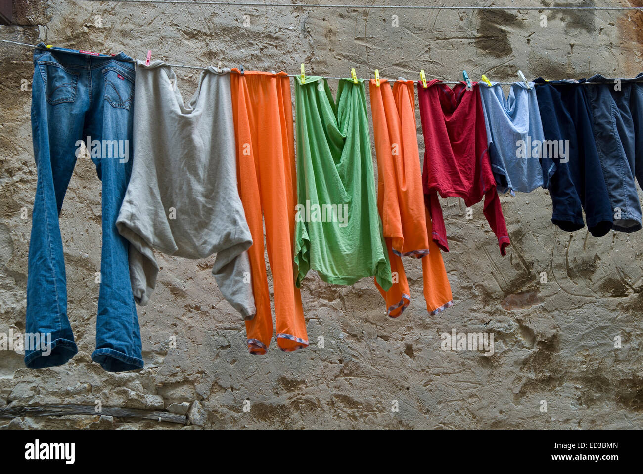 Lavages multicolores sont pendus dans la vieille ville. Vieux Mur loameux est arrière-plan de cette photo. Banque D'Images