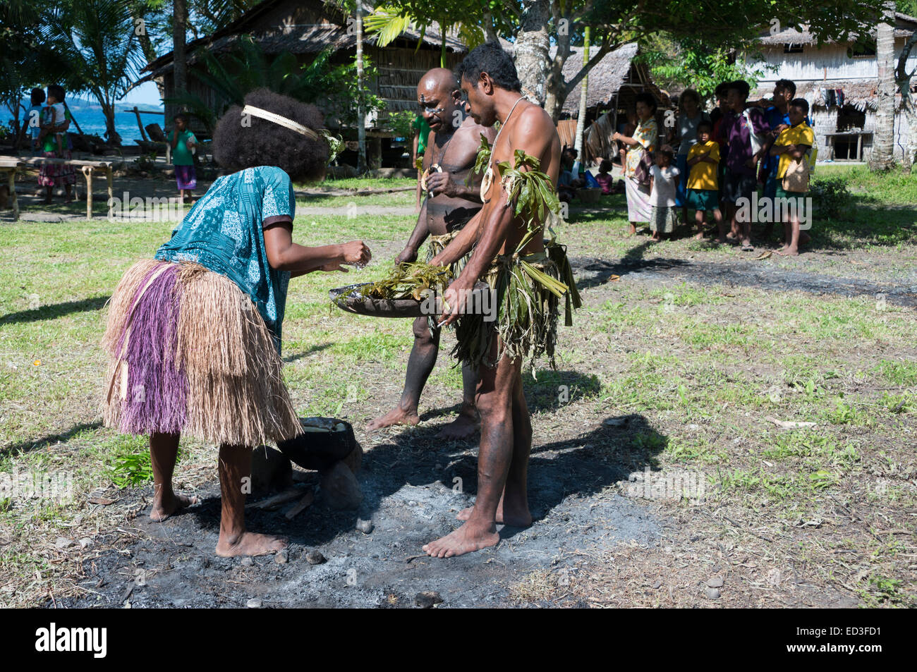 En Mélanésie, la Papouasie-Nouvelle-Guinée, l'île de Dobu. Jupe femme Village dans l'herbe avec la cuisson des poteries typiques de cruche à foyer ouvert. Banque D'Images