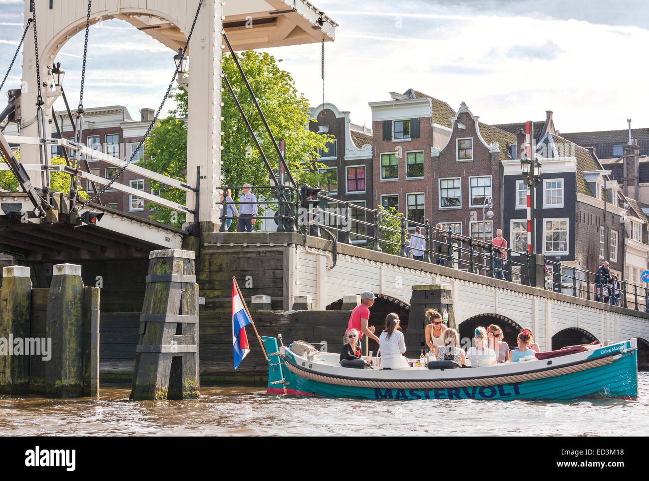 Amsterdam Amstel avec Skinny Bridge, Magere Brug avec location de bateaux électriques avec les filles, les jeunes femmes à faire la fête, boire du vin. Banque D'Images