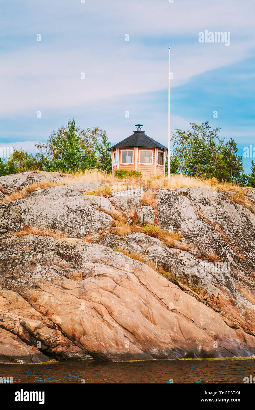 Recherche maison en bois finlandais jaune sur l'île de roche en été Banque D'Images Recherche maison en bois finlandais jaune sur l'île de roche en été Banque D'Images