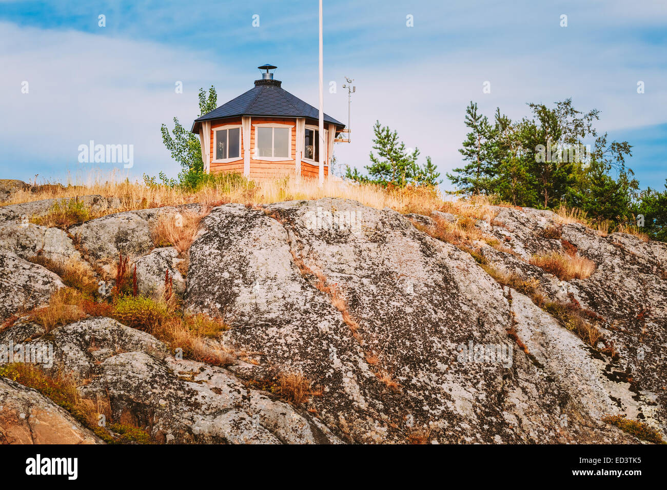 Recherche maison en bois finlandais jaune sur l'île de roche en été Banque D'Images Recherche maison en bois finlandais jaune sur l'île de roche en été Banque D'Images