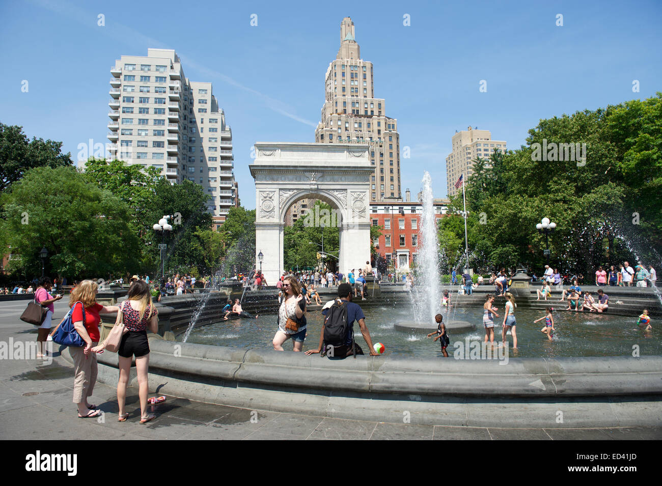 La VILLE DE NEW YORK, USA - Juin 2014 : Les gens se rassemblent à la fontaine à Washington Square Park sur un bel après-midi d'été. Banque D'Images