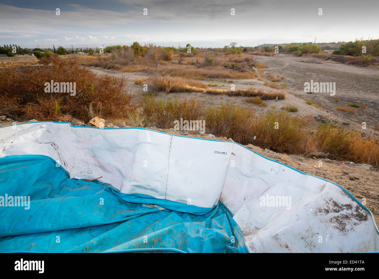 Un enfant abandonné pataugeoire à côté de la lit d'une rivière asséchée de la rivière Kern à Bakersfield, Californie, USA. À la suite d'une sécheresse sans précédent de quatre ans, Bakersfield est maintenant le plus sec des villes des USA. Banque D'Images