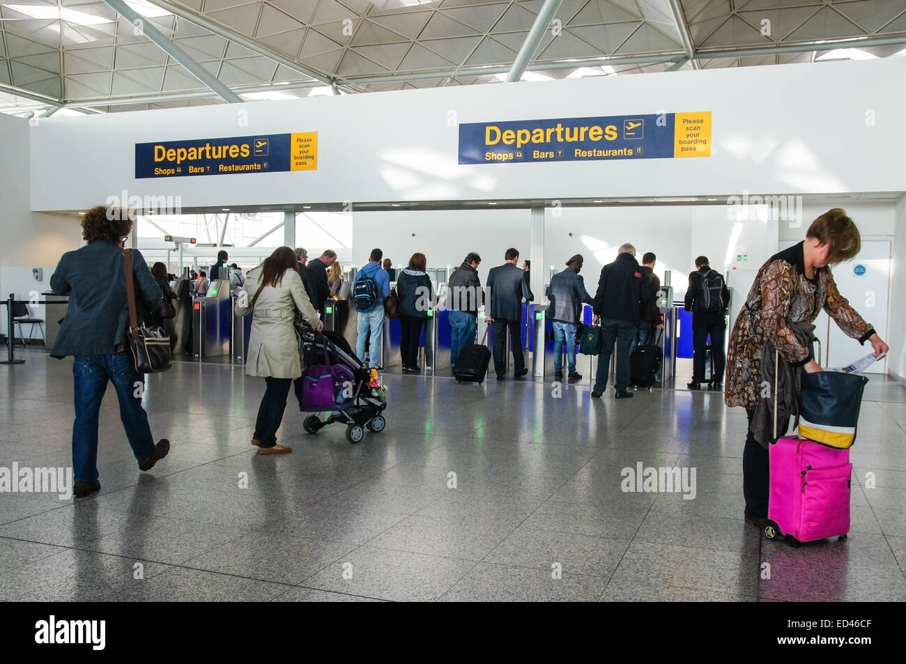 Passagers et voyageurs se rendant à la zone de départs à Londres Stansted aéroport Essex Angleterre Royaume-Uni Royaume-Uni Banque D'Images