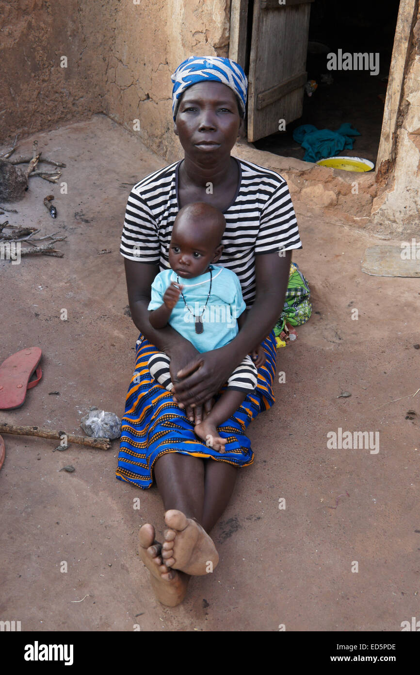 Femme et bébé à l'extérieur de la hutte de boue, Gambaga, Ghana Banque D'Images