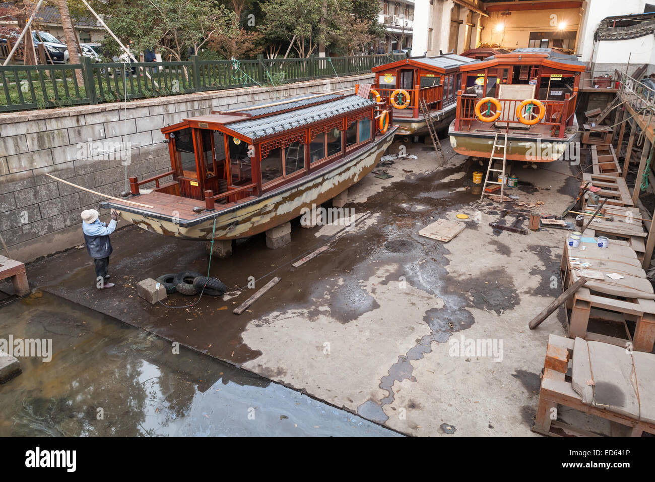 Hangzhou, Chine - décembre 5, 2014 : les loisirs en bois chinois traditionnels bateaux en rénovation dans le chantier naval. Lac de l'ouest d'authenticité Banque D'Images