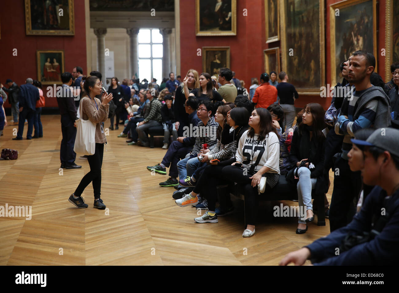 Asian female tour guide expliquant aux touristes à l'intérieur du Louvre Banque D'Images