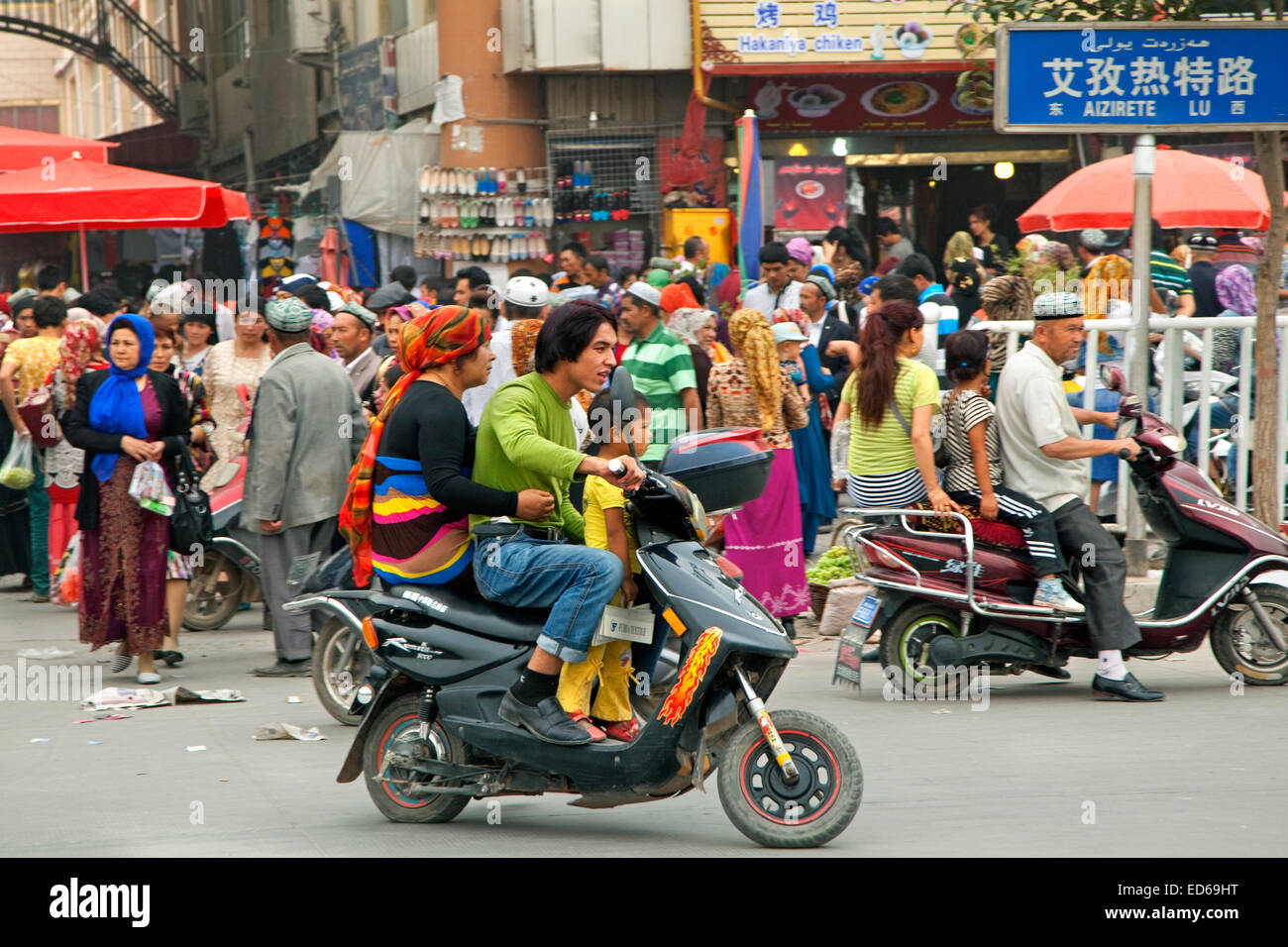 Les Chinois la trottinette, dans rue commerçante animée dans la ville Kashgar / Kashi, la Province du Xinjiang, Chine Banque D'Images