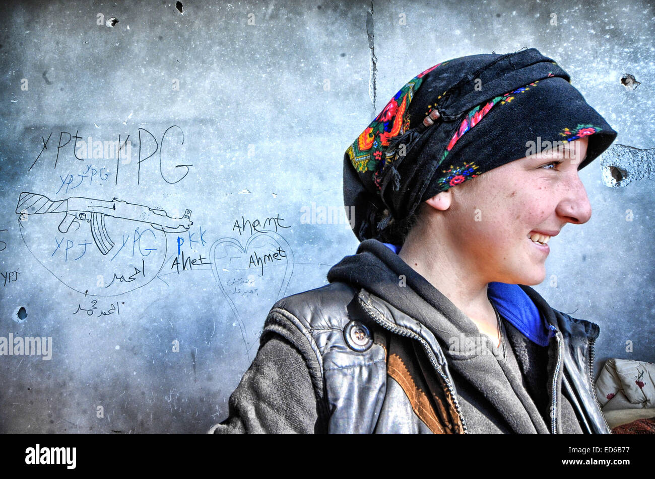 Kobane, la Syrie. Dec 21, 2014. Dans Kobane kurdes ordinaires, y compris les femmes et les personnes âgées, sont rapidement convertis en anciens combattants aguerris dans les rues et les ruines de ce qu'ils appellent ''Notre Stalingrad''. Les combats est mesurée en pieds ; les objectifs sont des bâtiments ou même des chambres dans les bâtiments. Les immeubles qui sont encore debout sont transformés en forteresses. Les deux côtés sont verrouillés dans un combat à mort. Les Kurdes à l'arrière il y a contre la Turquie et face à un ennemi qui les prive de leur humanité, il est en retraite. © Gail Orenstein/ZUMA/Alamy Fil Live News Banque D'Images