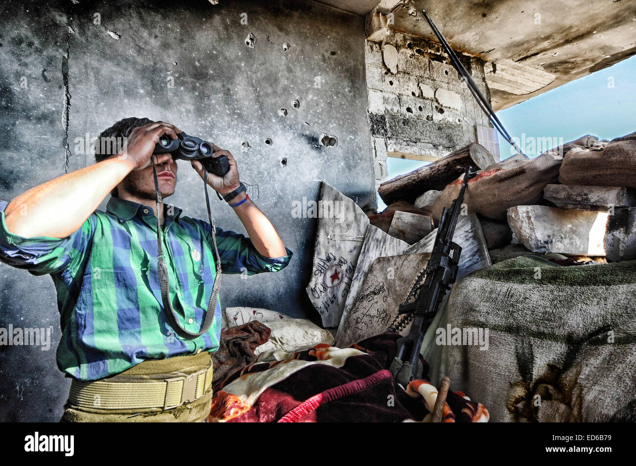 Kobane, la Syrie. Dec 21, 2014. Dans Kobane kurdes ordinaires, y compris les femmes et les personnes âgées, sont rapidement convertis en anciens combattants aguerris dans les rues et les ruines de ce qu'ils appellent ''Notre Stalingrad''. Les combats est mesurée en pieds ; les objectifs sont des bâtiments ou même des chambres dans les bâtiments. Les immeubles qui sont encore debout sont transformés en forteresses. Les deux côtés sont verrouillés dans un combat à mort. Les Kurdes à l'arrière il y a contre la Turquie et face à un ennemi qui les prive de leur humanité, il est en retraite. © Gail Orenstein/ZUMA/Alamy Fil Live News Banque D'Images
