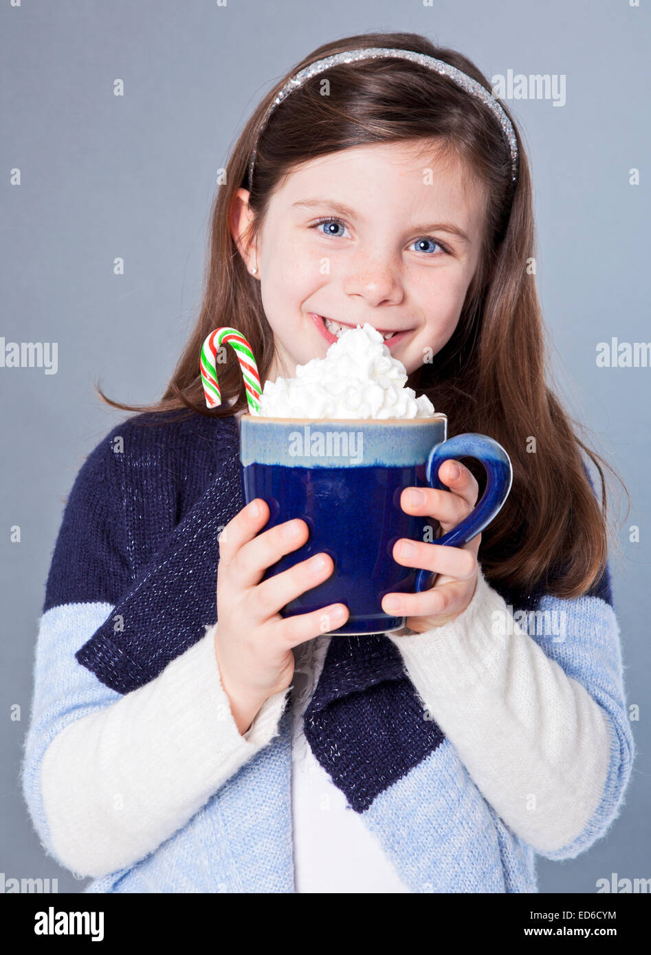 Jolie petite fille avec un chocolat chaud et un candycane Banque D'Images