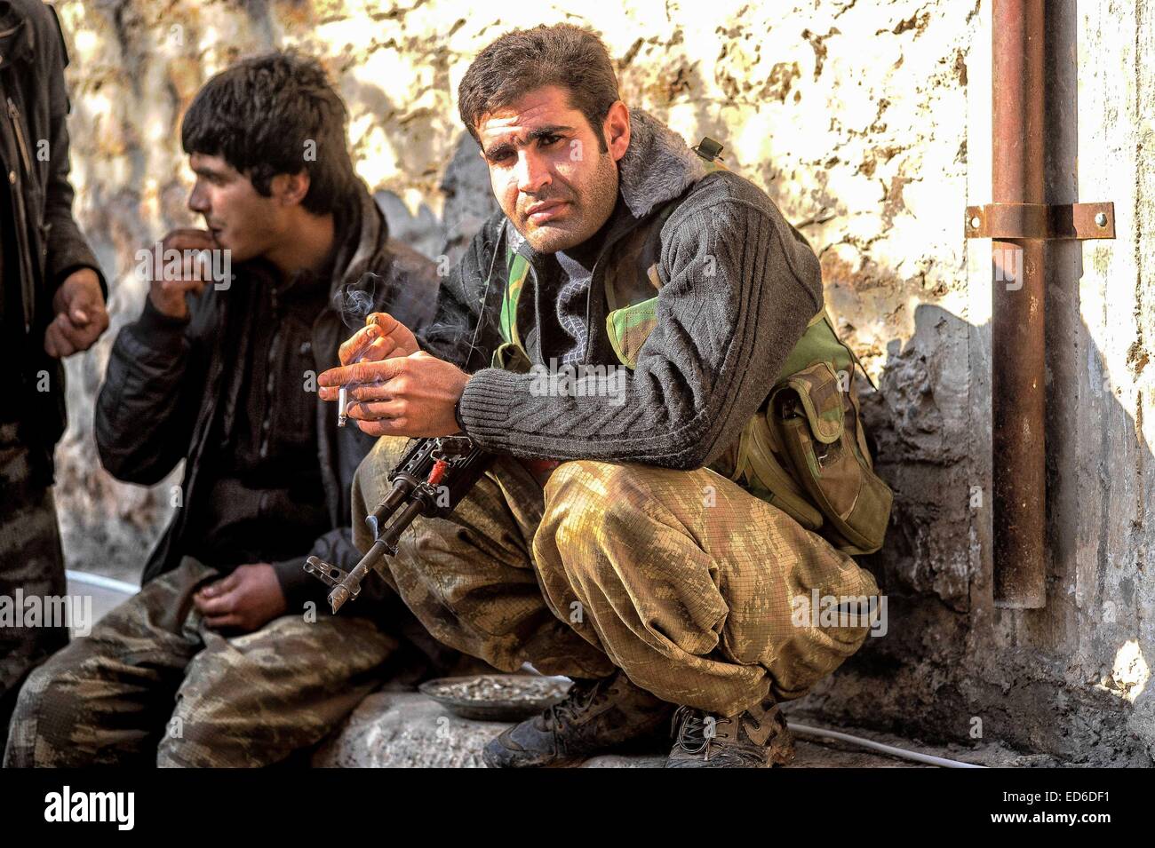 Kobane, la Syrie. Dec 21, 2014. Dans Kobane kurdes ordinaires, y compris les femmes et les personnes âgées, sont rapidement convertis en anciens combattants aguerris dans les rues et les ruines de ce qu'ils appellent ''Notre Stalingrad''. Les combats est mesurée en pieds ; les objectifs sont des bâtiments ou même des chambres dans les bâtiments. Les immeubles qui sont encore debout sont transformés en forteresses. Les deux côtés sont verrouillés dans un combat à mort. Les Kurdes à l'arrière il y a contre la Turquie et face à un ennemi qui les prive de leur humanité, il est en retraite. © Gail Orenstein/ZUMA/Alamy Fil Live News Banque D'Images