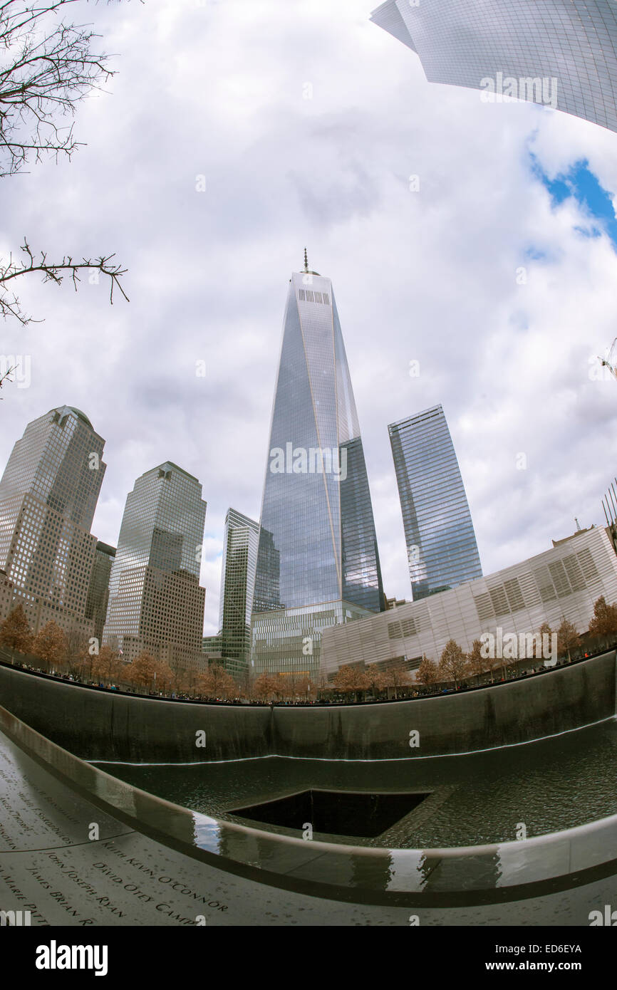 One World Trade Center se lève sur les visiteurs du Mémorial National du 11 septembre & Museum de New York à Noël, le Jeudi, Décembre 25, 2014. Le monument commémoratif est composé de deux piscines sur les traces du World Trade Center et d'une place plantée de plus de 400 arbres chêne bicolore. Les noms des 2983 victimes des attentats du 11 septembre et février 1993 le WTC sont inscrits autour de la base de l'eau. (© Richard B. Levine) Banque D'Images