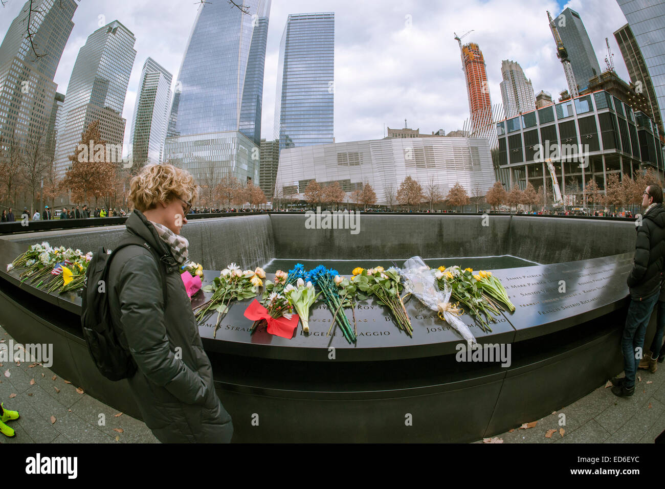 Les visiteurs du Mémorial National du 11 septembre & Museum de New York à Noël, le Jeudi, Décembre 25, 2014. Le monument commémoratif est composé de deux piscines sur les traces du World Trade Center et d'une place plantée de plus de 400 arbres chêne bicolore. Les noms des 2983 victimes des attentats du 11 septembre et février 1993 le WTC sont inscrits autour de la base de l'eau. (© Richard B. Levine) Banque D'Images